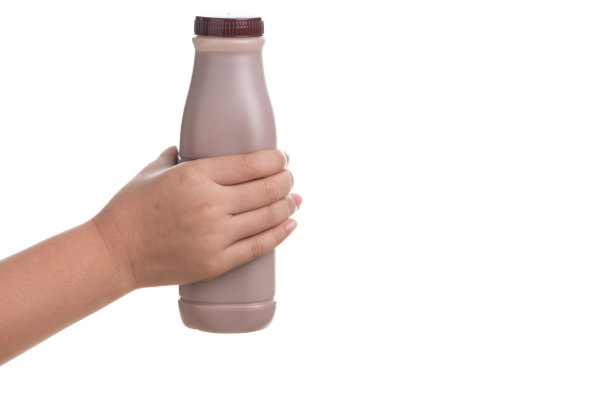 手拿一瓶鲜牛奶巧克力孤立在白色背景。图片下载