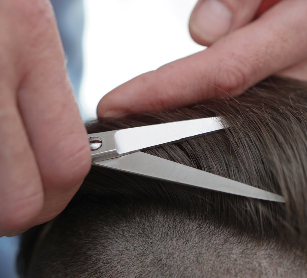 理发师理发的过程。沙龙里的男人捋着头发。用剪刀手。设计图片图片下载