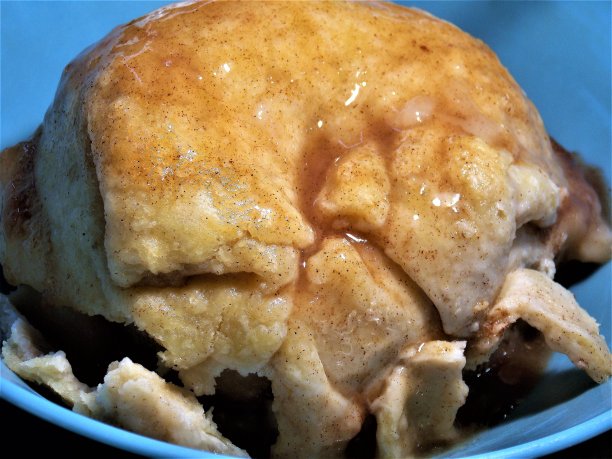 皇家免费照片-奇妙的食物背景-一个颓然美味的自制苹果饺子的特写-甜蜜的感觉-完美的烘焙食物的照片-一个惊人的大苹果饺子甜点-苹果饺子游泳在甜的甜糖浆图片下载