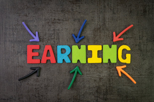 多色箭头指向在黑色水泥黑板墙中心的“收入”字，企业利润或收入来自公司和公司图片下载