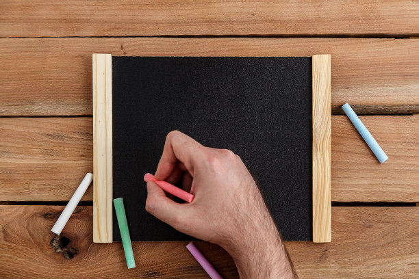 女人手在木制背景的木制黑板上写字，顶视图图片下载