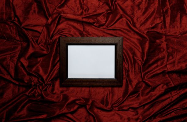 猩红色丝绸背景上的木制空画框图片下载