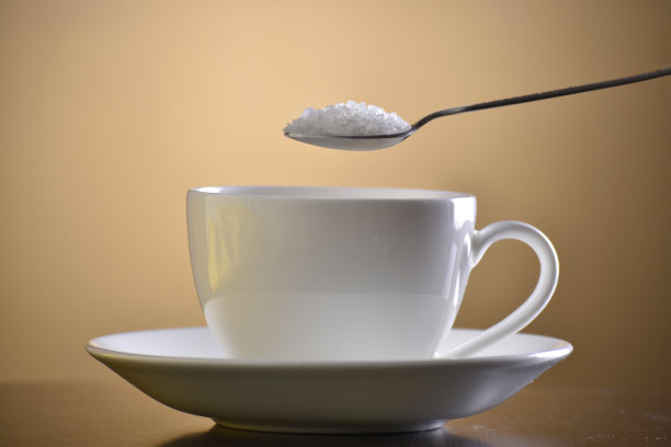 糖倒进仪式杯中，以棕色为背景，图片下载