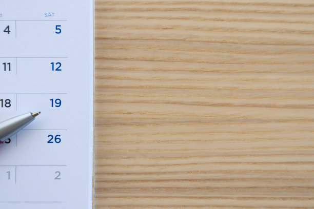 日历页上的木桌背景与笔尖在19日图片下载