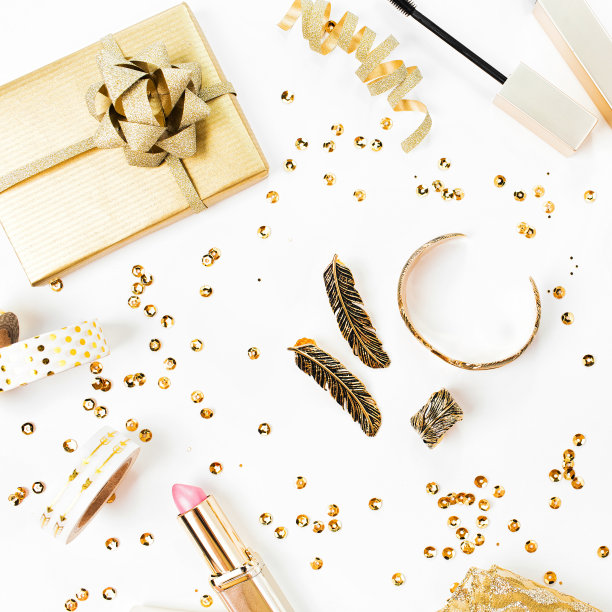 框架与礼物，亮片，化妆化妆品工具包和其他配件在白色的背景。金色的构图。平躺，俯视图。图片下载