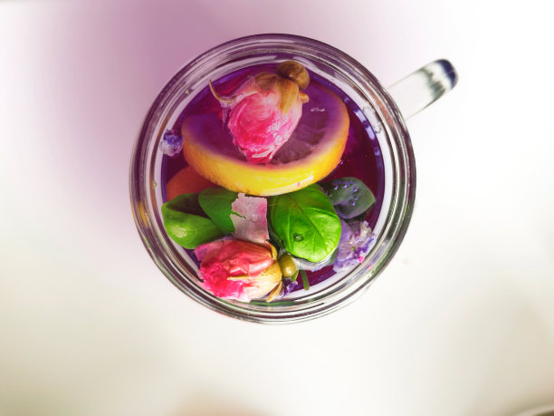 泰国亚洲紫色安山茶在鸡尾酒杯与干玫瑰花蕾，柠檬片，罗勒叶，健康有机排毒亚洲草药茶阴蒂蝴蝶豌豆顶部景观与粉色阴影图片下载