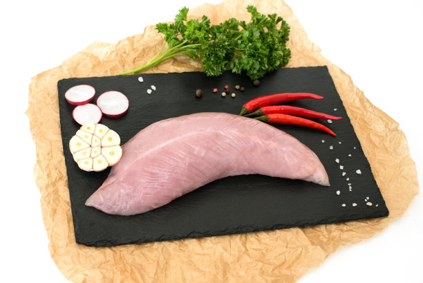 生火鸡肉里脊，白肉胸脯，饮食产品为适当的营养，在黑色的石头板与香料，准备烹饪，在白色孤立的背景。图片下载