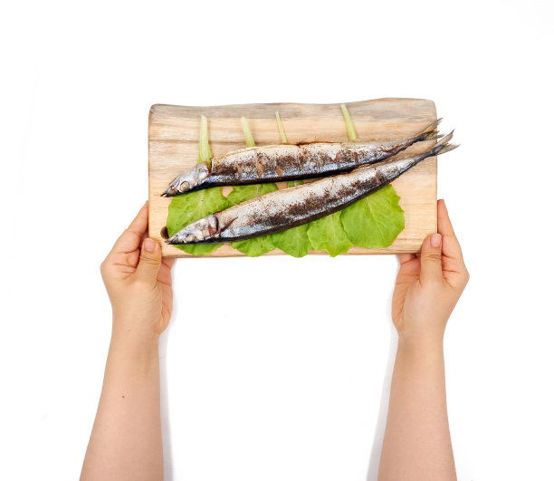 女性手握烤太平洋鲷鱼在一个白色的背景图片下载