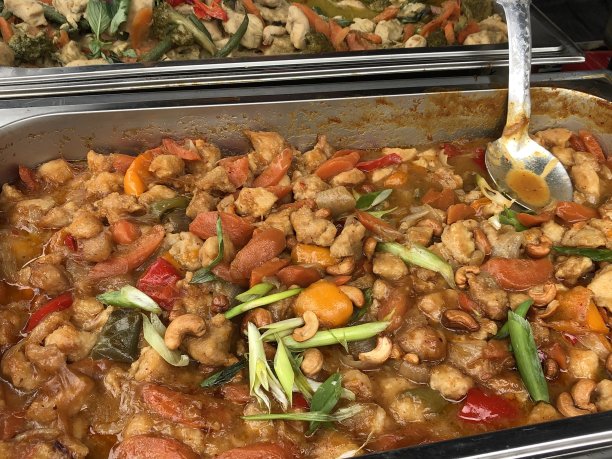 这是街头小吃市场的红绿色泰式咖喱食谱，放在热盘子上保温，随时可以食用。泰式咖喱配鸡肉、柠檬草、辣椒、椰奶和香料图片下载