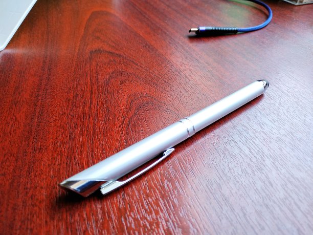 黑色的办公桌上放着一支钢笔图片下载