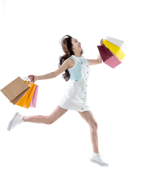 快乐的女人拿着购物袋在白色的背景图片下载