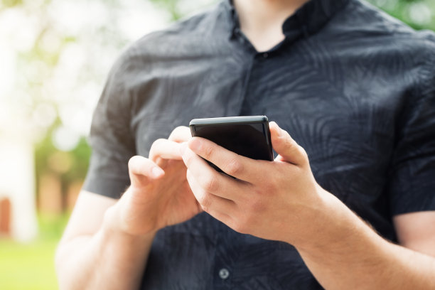 一个男人的手在用智能手机，特写。图片下载