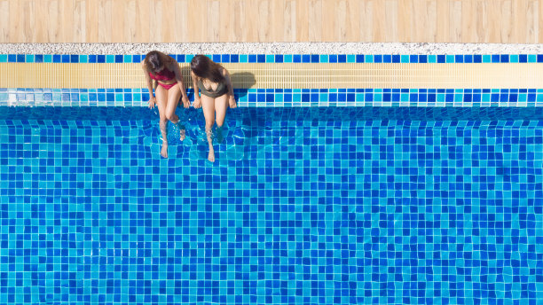 享受晒黑。假期的概念。俯视图苗条的年轻女子戴着帽子在大游泳池。图片下载