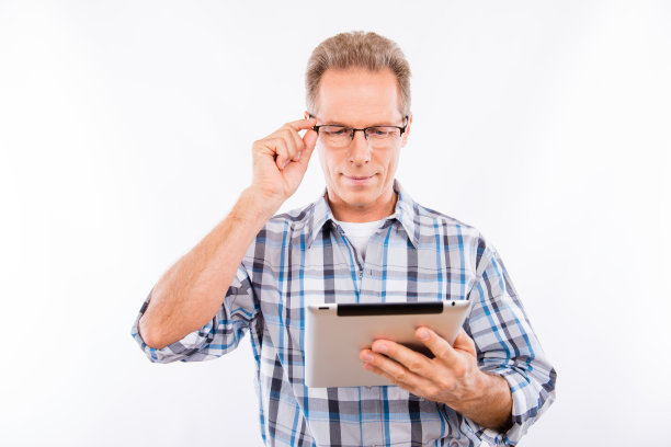 英俊快乐的老人戴着眼镜拿着平板电脑图片下载