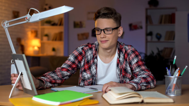 十几岁的学生看着家人的照片，想念父母，远离家乡学习图片下载