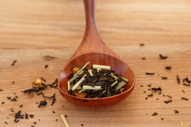 用木勺舀着干果的红茶，以木色为背景图片下载