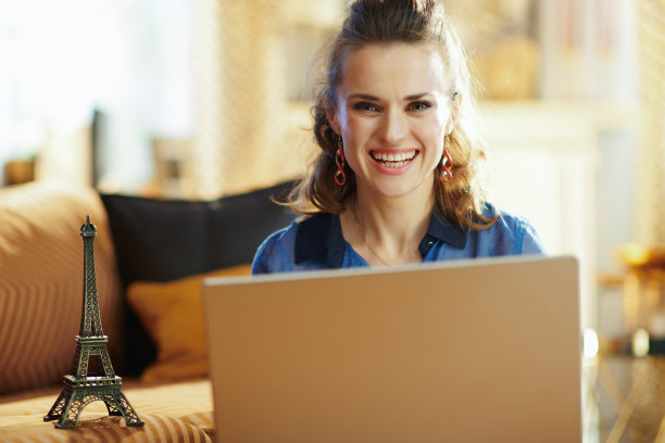 快乐的现代女人用笔记本电脑纪念埃菲尔铁塔图片下载