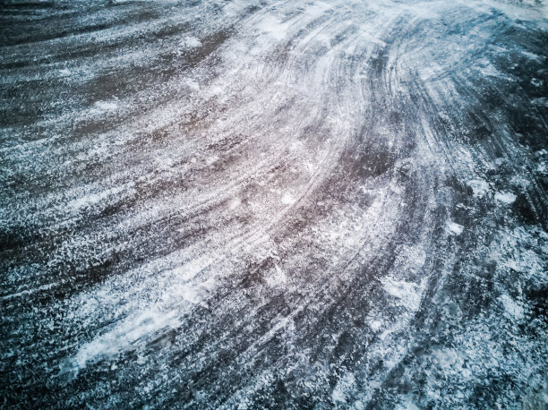 沥青从雪中清除。纹理。扫把上的条纹。第一场雪落在城市里。冬天图片下载