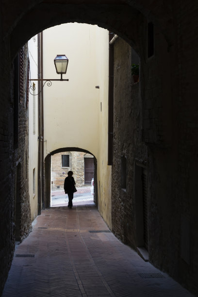 意大利托斯卡纳圣吉米尼亚诺的中世纪风格小巷里的一位女士图片下载