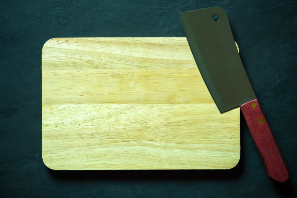 黑水泥地板上的木制砧板和中式厨刀。图片下载