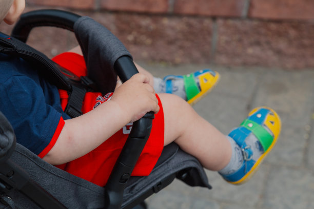 一个阳光明媚的小男孩坐在婴儿车里图片下载