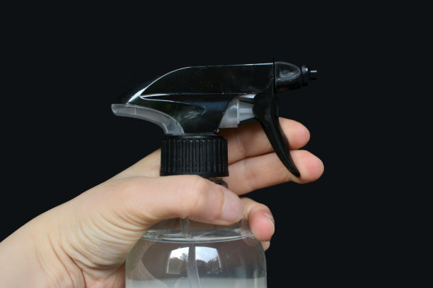 小女性手握喷瓶清洁剂在黑色背景图片下载