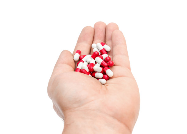 手捧红白相间的胶囊。孤立在白色的。图片下载