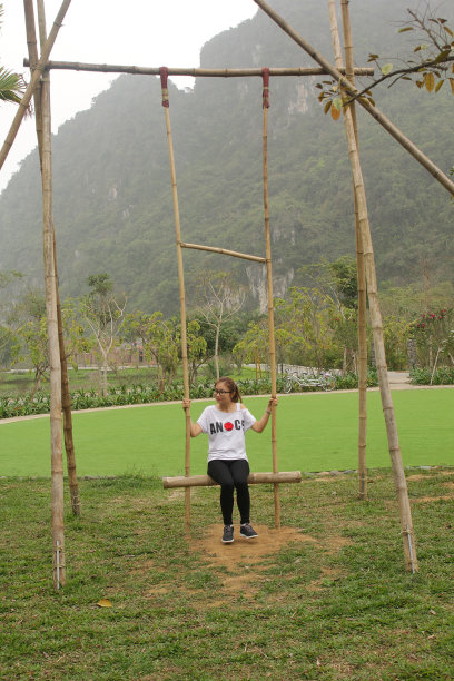 美丽的女孩非常高兴在山的旁边荡秋千图片下载