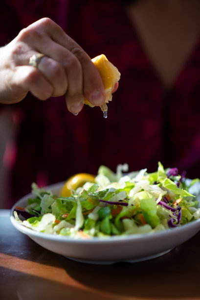 把柠檬汁挤在沙拉上图片下载