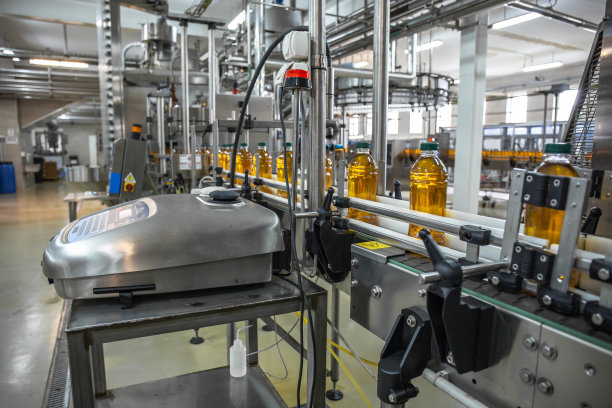 在现代饮料厂或工厂化生产中，塑料瓶与果汁在自动传送线或皮带上图片下载