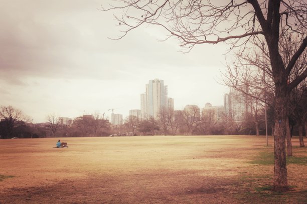 懒惰的时间。放松的女孩坐在草地上在冬天与阴天图片下载