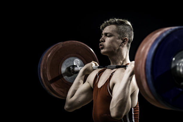 年轻的举重运动员举着杠铃图片下载