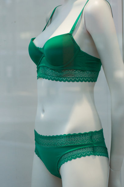 在时装商店的女装陈列室里，穿着绿色内衣的模特图片下载