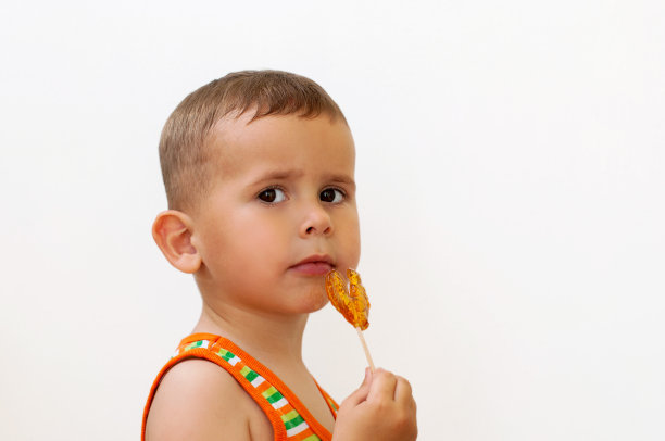 漂亮的两岁男孩拿着棒棒糖图片下载