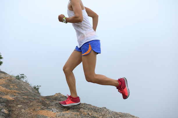 年轻的健身女子跑上海边的山顶图片下载