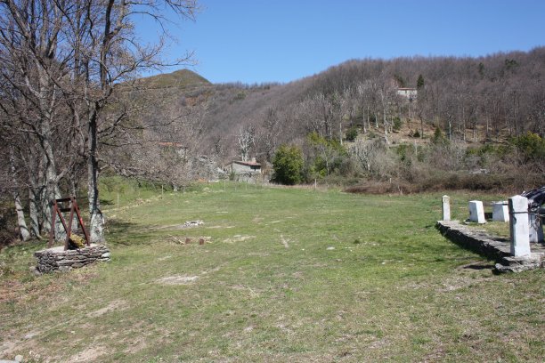 在托斯卡纳亚平宁地区的阿普利亚阿尔卑斯山脉上一大片绿色空地上被遗弃的小房子图片下载