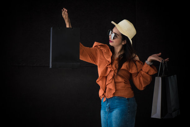 亚洲购物女性喜欢黑色星期五购物袋的黑色背景。购物狂和美容时尚主题。图片下载