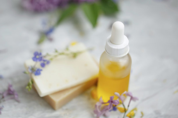 鲜花、天然香皂和精油瓶水疗静物，水疗和健康背景下的天然面部和身体护理产品图片下载