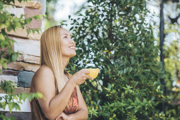 早上喝拿铁咖啡的快乐年轻女人图片下载