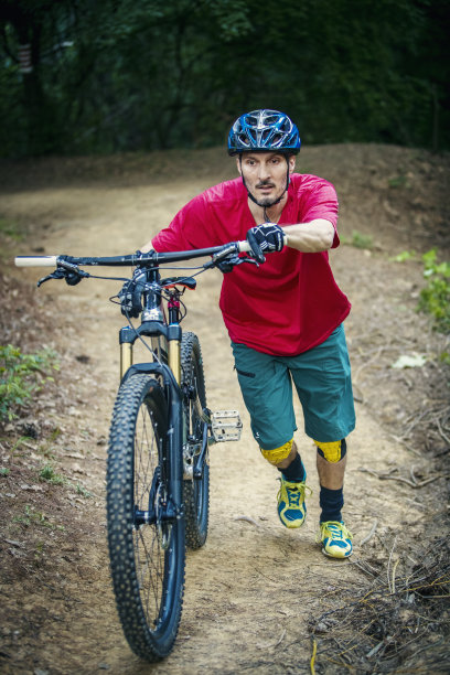 骑自行车的人在森林里背着山地车图片下载