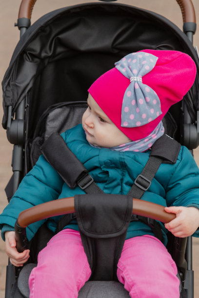 小女孩坐在街上的婴儿车里图片下载