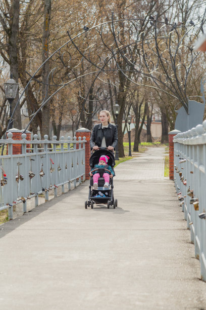年轻的母亲推着婴儿车走着图片下载