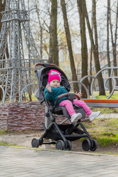 小女孩坐在街上的婴儿车里图片下载