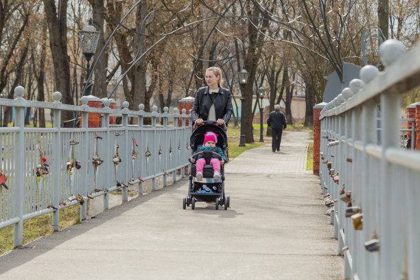 年轻的母亲推着婴儿车走着图片下载