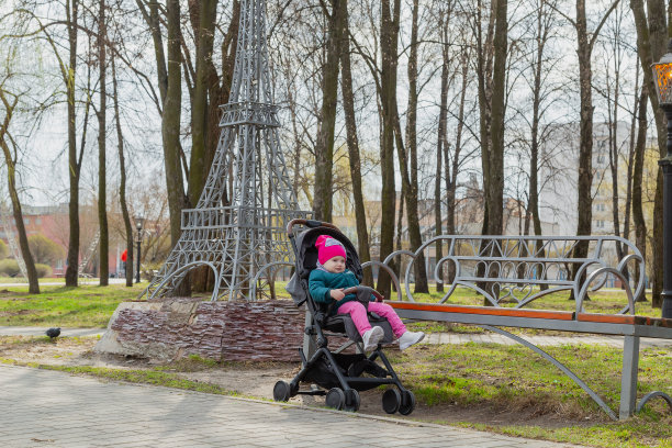 小女孩坐在街上的婴儿车里图片下载