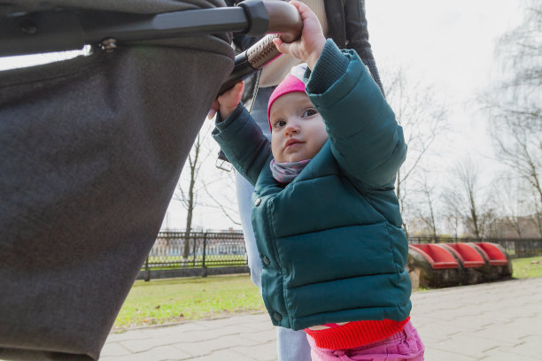 年轻的母亲推着婴儿车走着图片下载