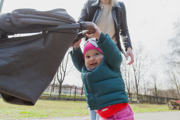 年轻的母亲推着婴儿车走着图片下载