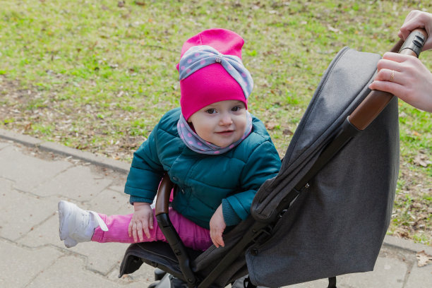 小女孩坐在街上的婴儿车里图片下载