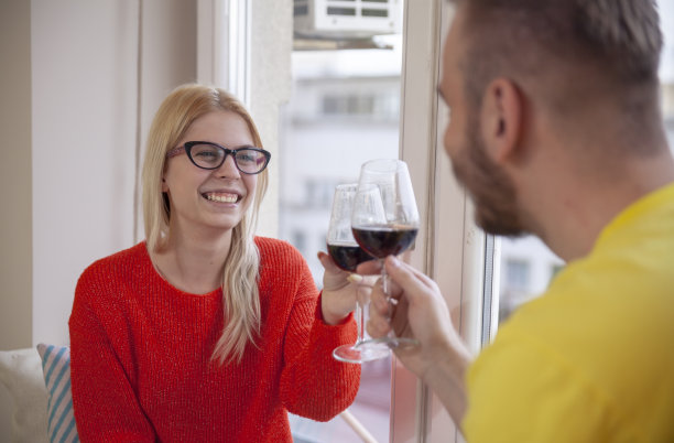 一个年轻女孩，向一个男人敬酒(镜头模糊)。图片下载