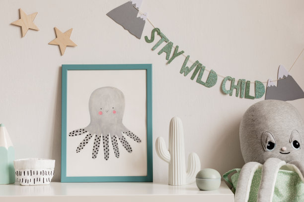 舒适的斯堪的纳维亚托儿所室内模拟相框，毛绒章鱼，仙人掌和儿童配件。白色背景墙上挂着时尚的题字和星星。模板。真实的照片。图片下载